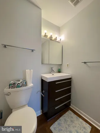 a bathroom with a sink mirror vanity and toilet