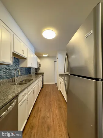 a large kitchen with a refrigerator a sink and dishwasher