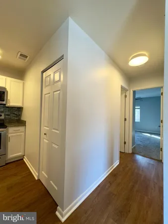 a view of a hallway with closet and wooden floor
