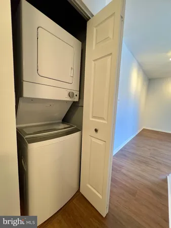 a utility room with wooden floor washer and dryer