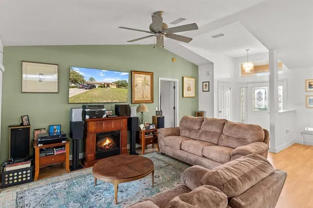 a view of a livingroom with furniture a ceiling fan and window