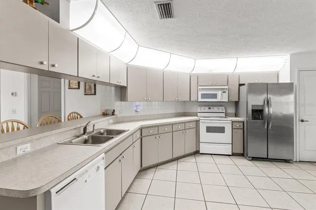 a kitchen with a sink a refrigerator and cabinets