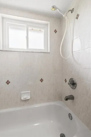 a view of empty room with window and wooden floor