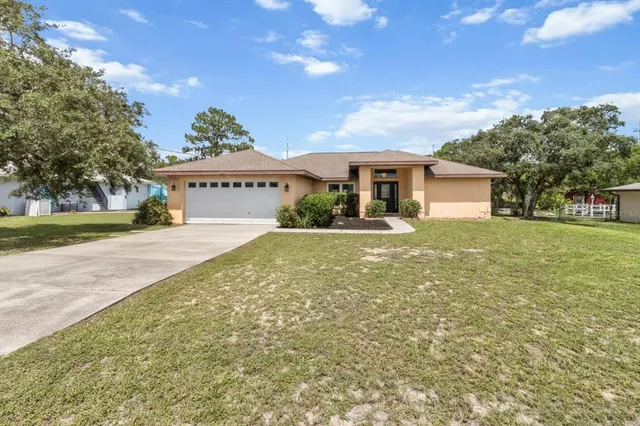 a front view of a house with a yard and potted plants