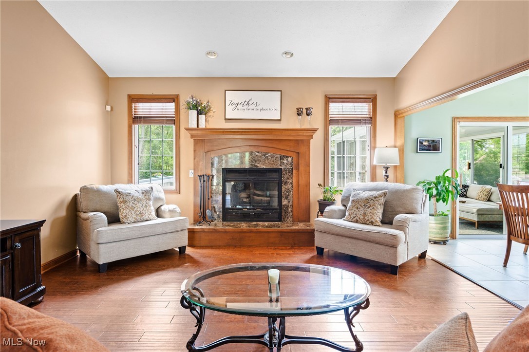 7644 Morley Road Mentor, OH 44060 - Photo 11 of 50 View of Great Room featuring a gorgeous fireplace, laminate floors, and access to the open concept Dining Room and the vaulted screened Sun Room