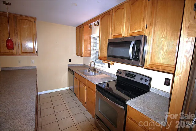 a kitchen with stainless steel appliances granite countertop a stove a sink and a microwave
