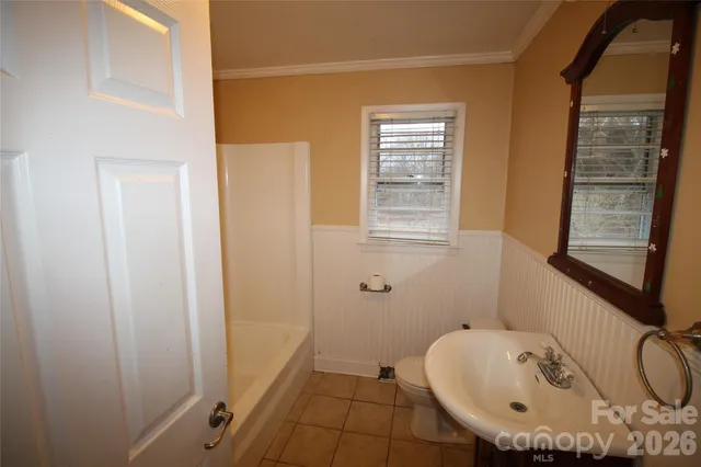 a bathroom with a sink a window and a shower