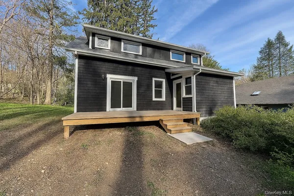 a view of a house with a yard and sitting area