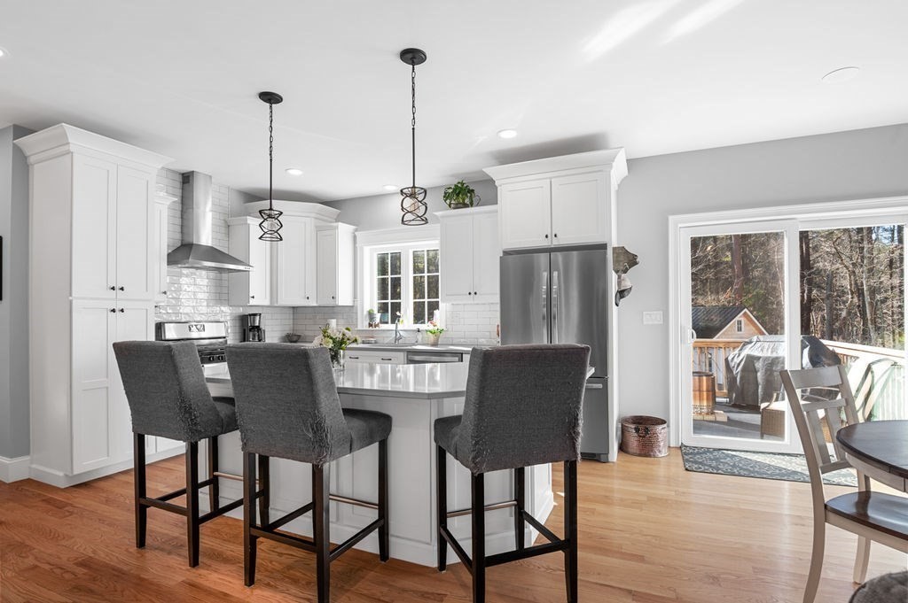 600 Wethersfield Street Rowley, MA 01969 - Photo 16 of 42 a view of a dining room and livingroom with furniture wooden floor a chandelier