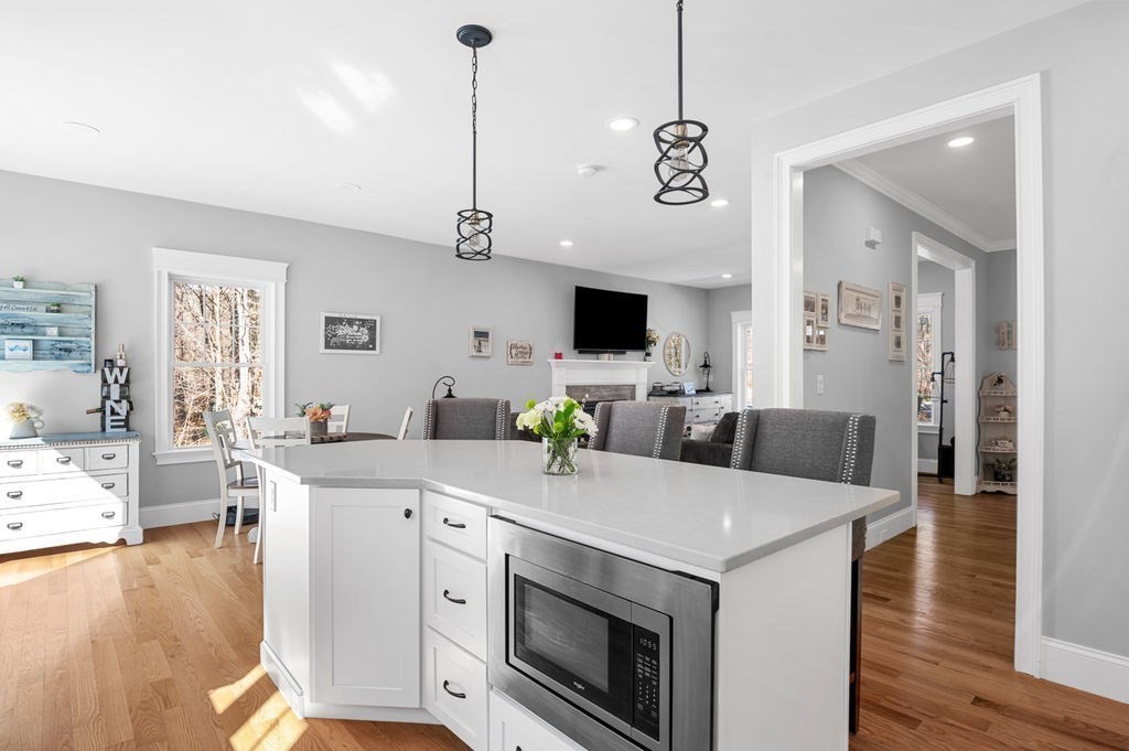 600 Wethersfield Street Rowley, MA 01969 - Photo 17 of 42 a living room with stainless steel appliances kitchen island granite countertop a stove a sink a dining table and chairs with wooden floor