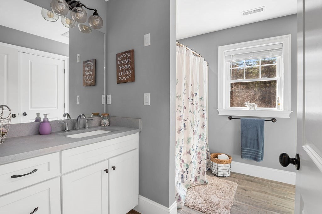 600 Wethersfield Street Rowley, MA 01969 - Photo 37 of 42 a spacious bathroom with a granite countertop sink a mirror a vanity and a shower