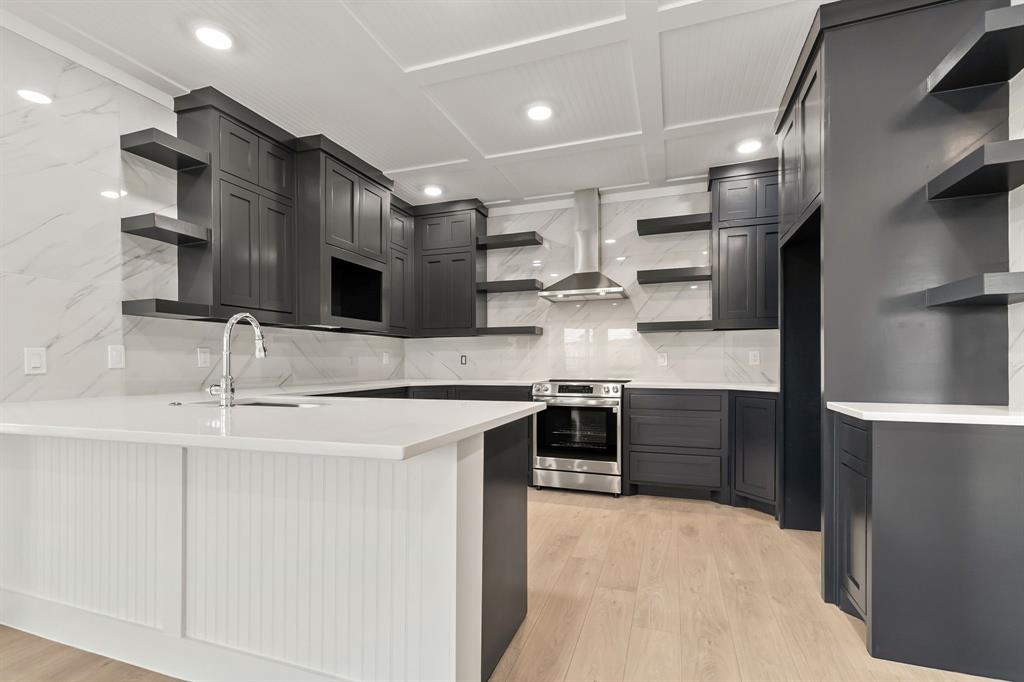 a large kitchen with stainless steel appliances kitchen island granite countertop a sink and cabinets