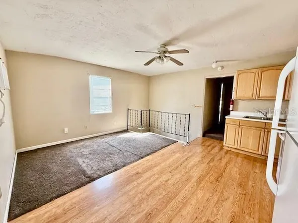 a view of a bedroom with a bed and wooden floor