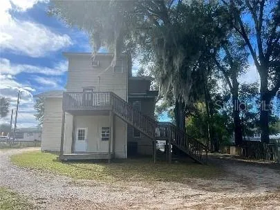 a view of a house with a garden and a tree