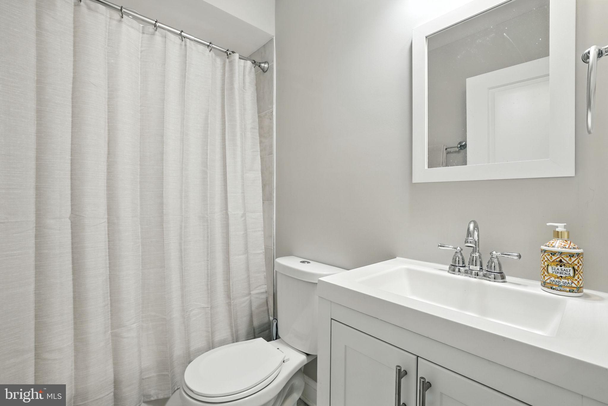 835 Oglethorpe Street Northeast Washington, DC 20011 - Photo 17 of 22 a bathroom with a sink a toilet and a mirror