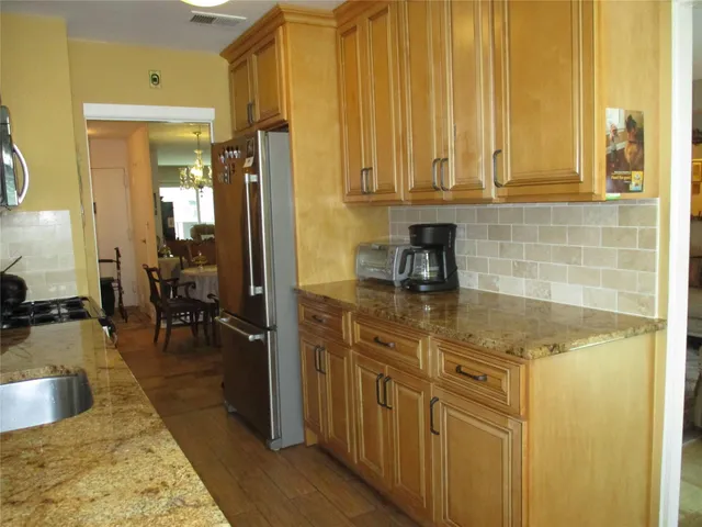 a kitchen with stainless steel appliances granite countertop a sink a stove and a refrigerator