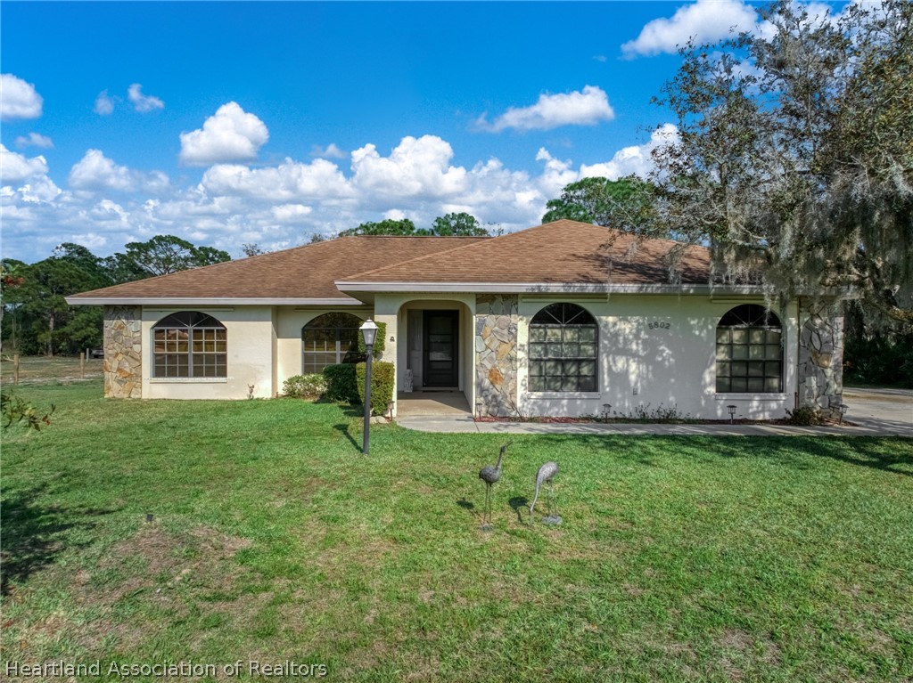 5802 Golden Road Sebring, FL 33875 - Photo 2 of 37 a front view of a house with a garden