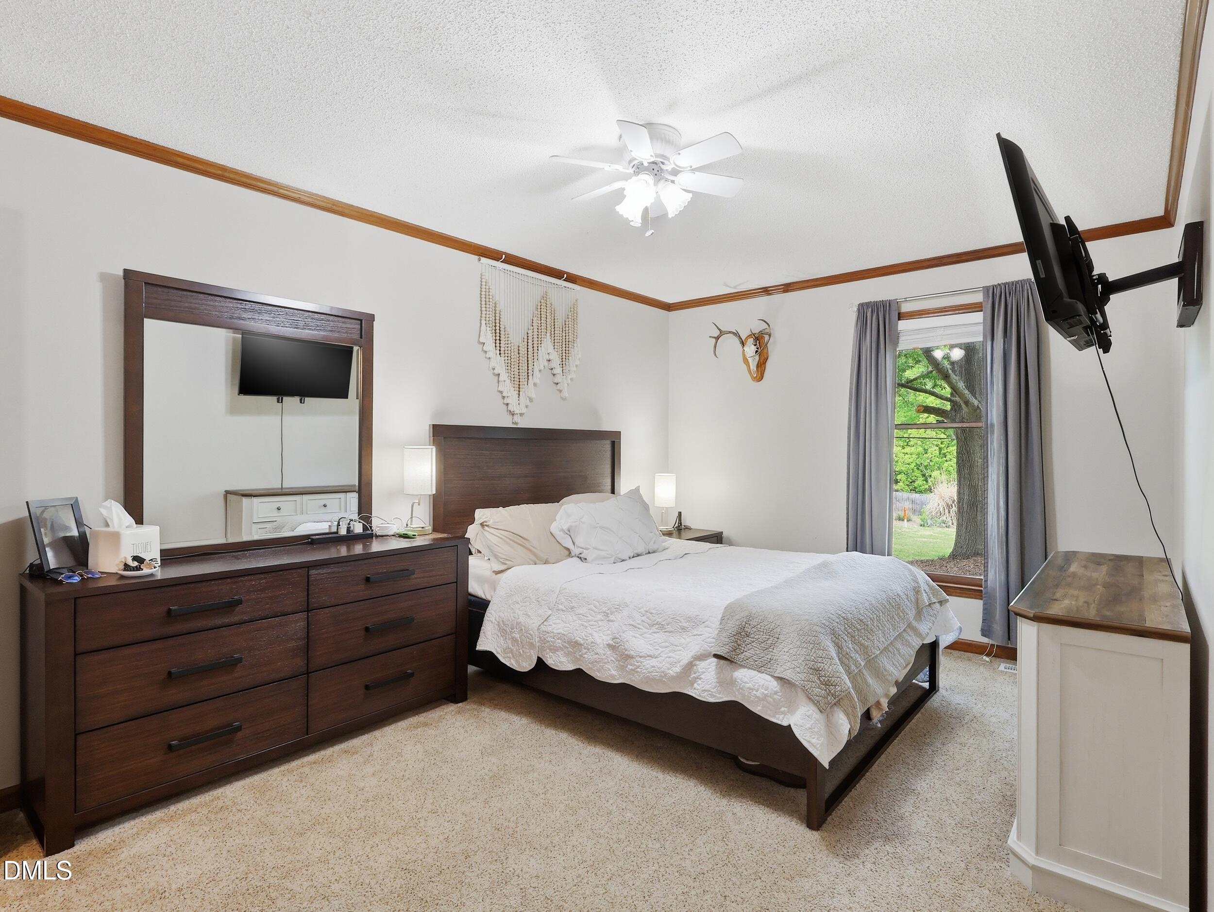 517 Lake Glad Road Wendell, NC 27591 - Photo 17 of 36 a bedroom with a bed a mirror on dresser and a window