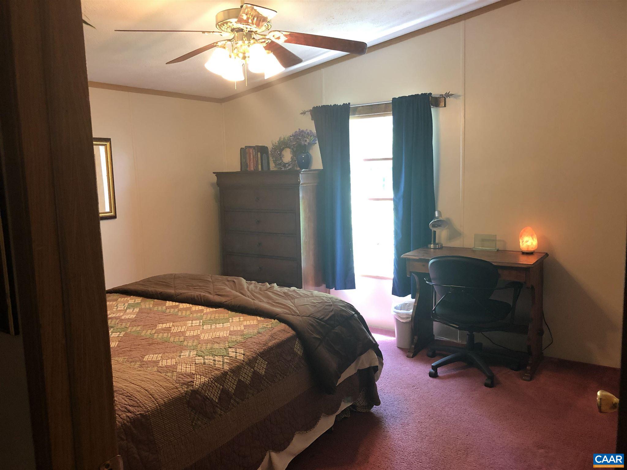 583 Rippin Run Road Ruckersville, VA 22968 - Photo 14 of 28 a bedroom with a bed and a chandelier