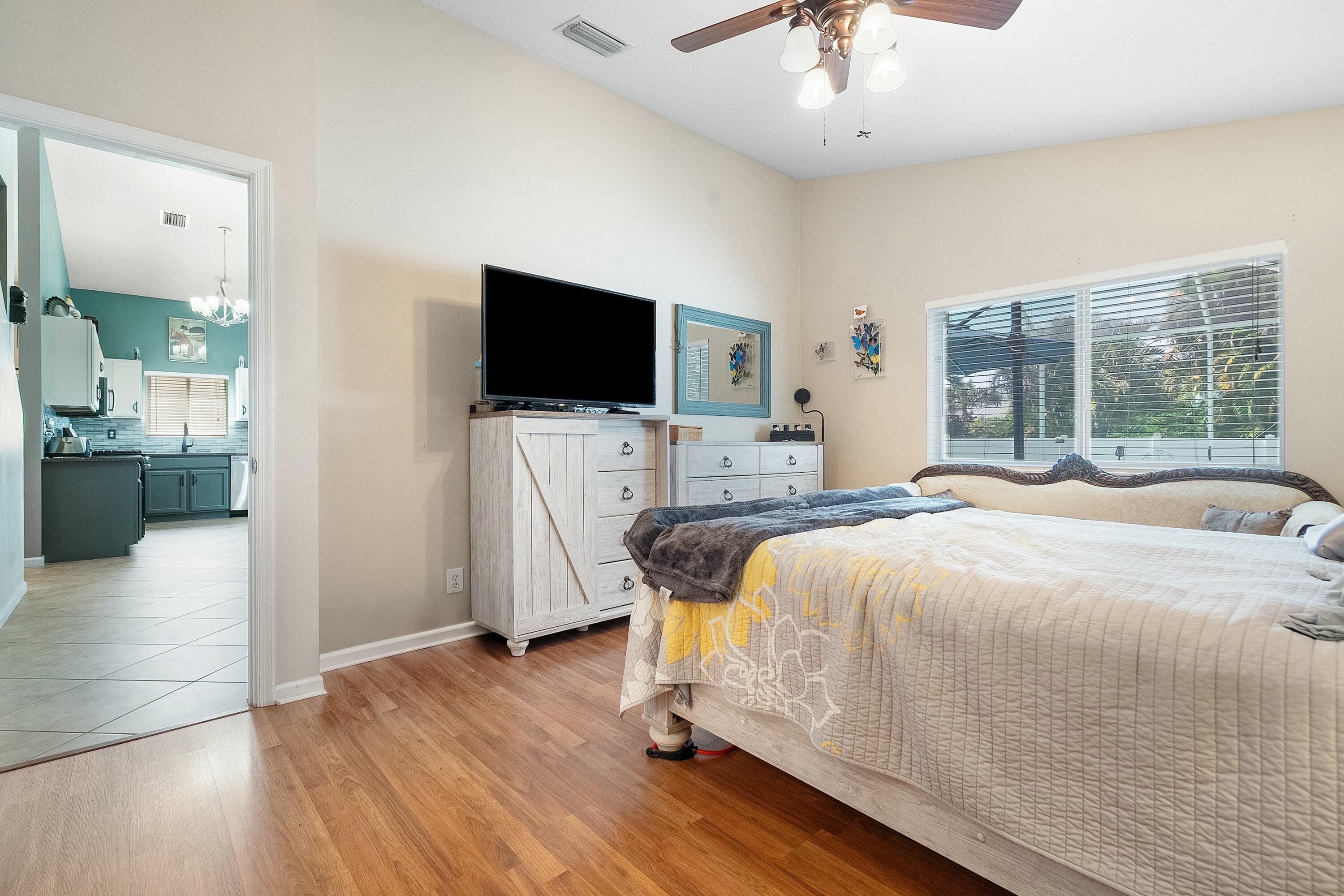 2480 Southeast Springtree Place Stuart, FL 34997 - Photo 17 of 39 a bedroom with a bed and a flat screen tv