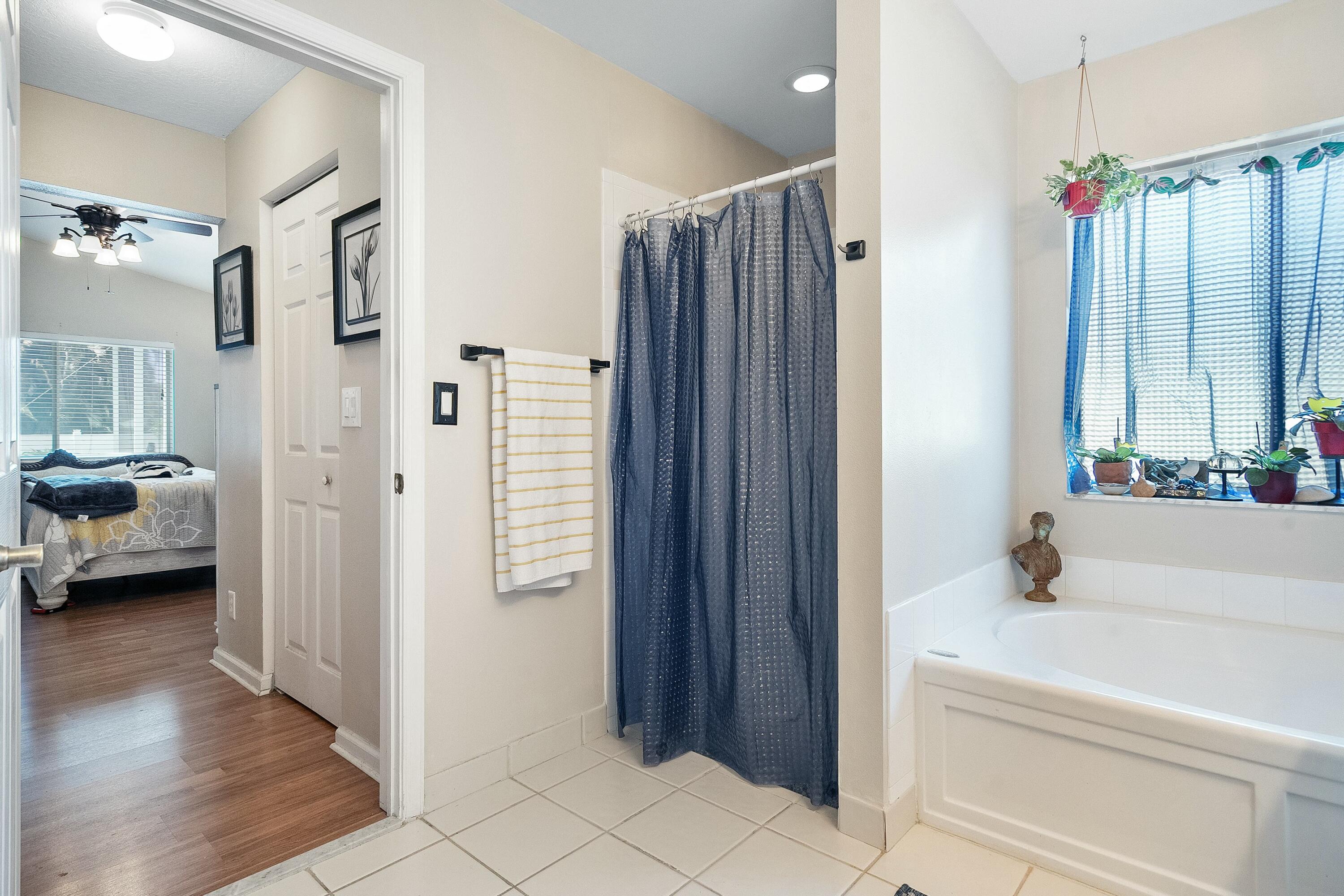 2480 Southeast Springtree Place Stuart, FL 34997 - Photo 20 of 39 a en suite bathroom with a tub shower and mirror