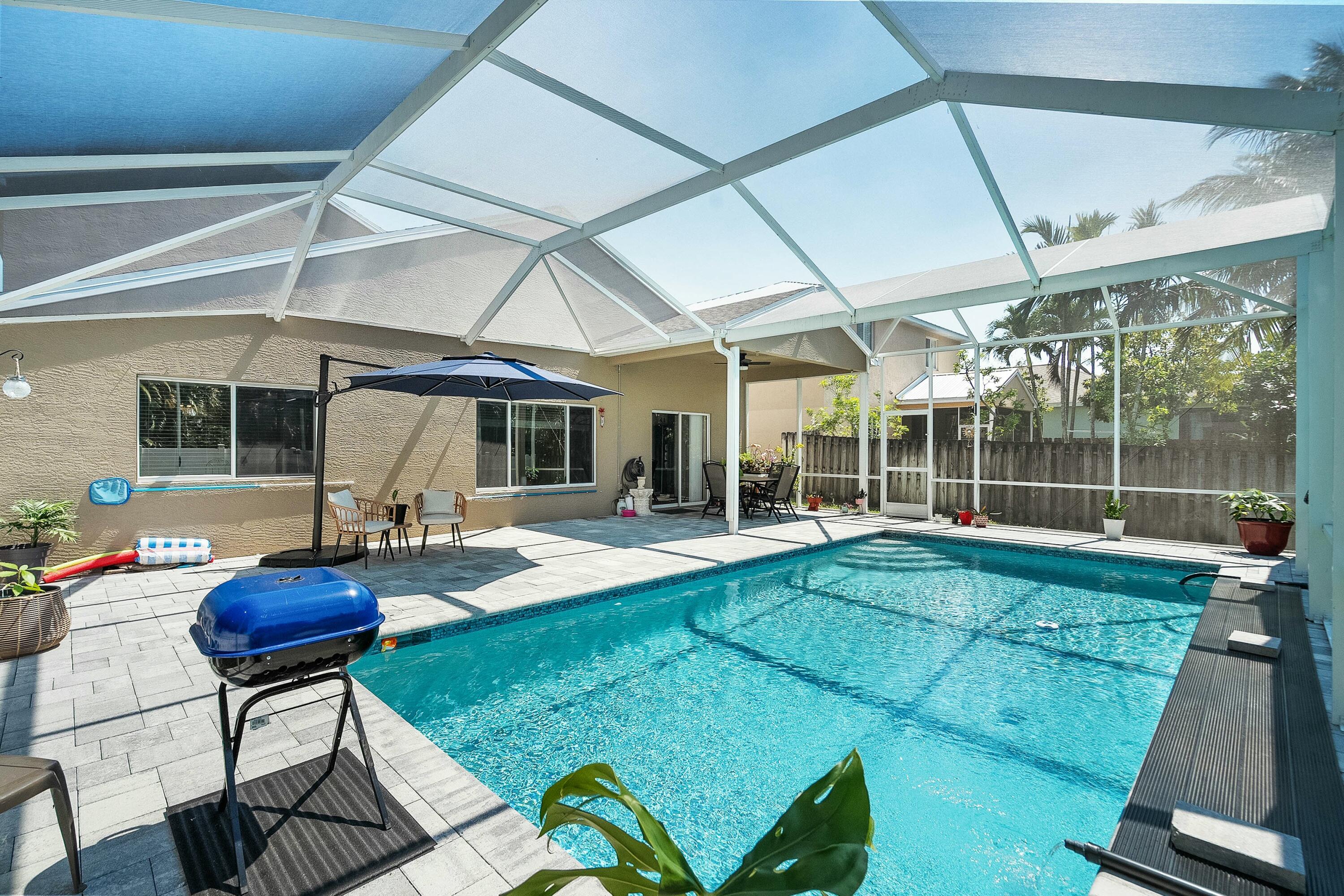 2480 Southeast Springtree Place Stuart, FL 34997 - Photo 29 of 39 a view of a house with backyard sitting area and swimming pool