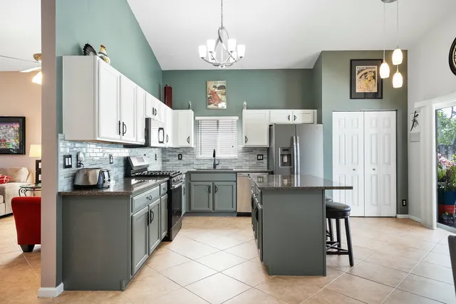 a kitchen with stainless steel appliances granite countertop a refrigerator and a stove