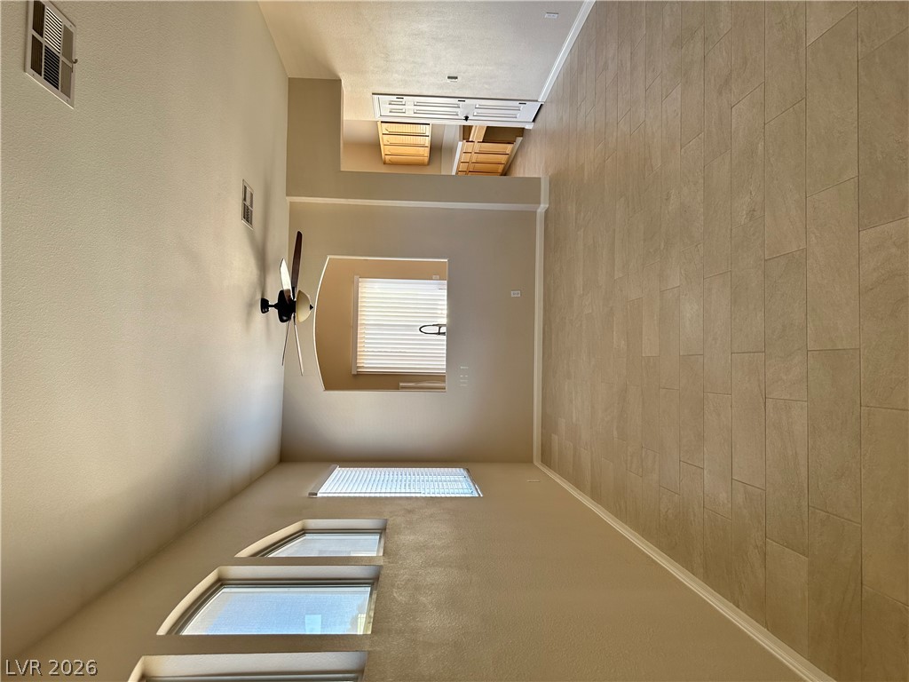 1922 Thunder Ridge Circle Henderson, NV 89012 - Photo 3 of 27 Natural light illuminates this spacious living area with tall ceilings and modern tile flooring.