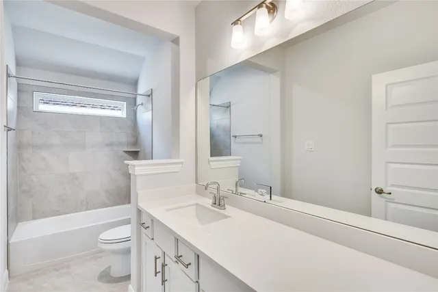 a bathroom with a sink a toilet a mirror and shower