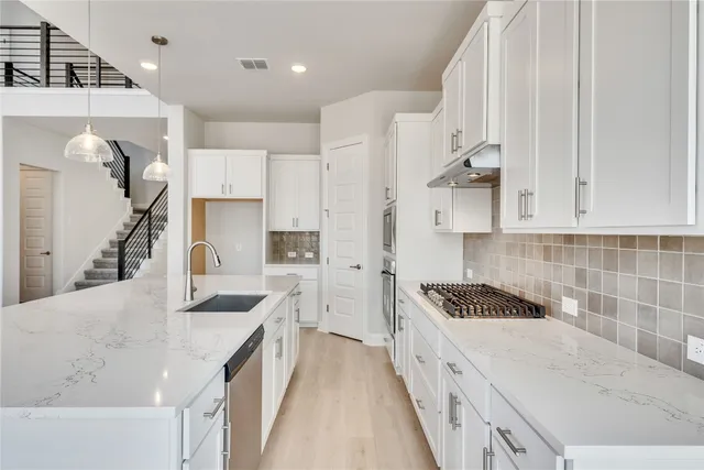 a kitchen with white cabinets and appliances