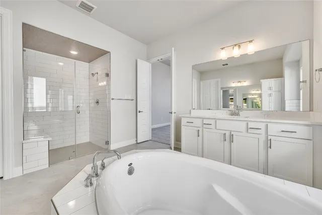 a spacious bathroom with a shower tub double sink and mirror