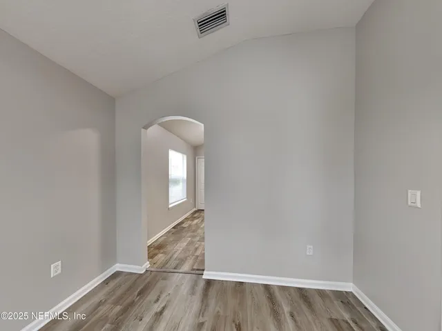 a view of a room with wooden floor and white walls