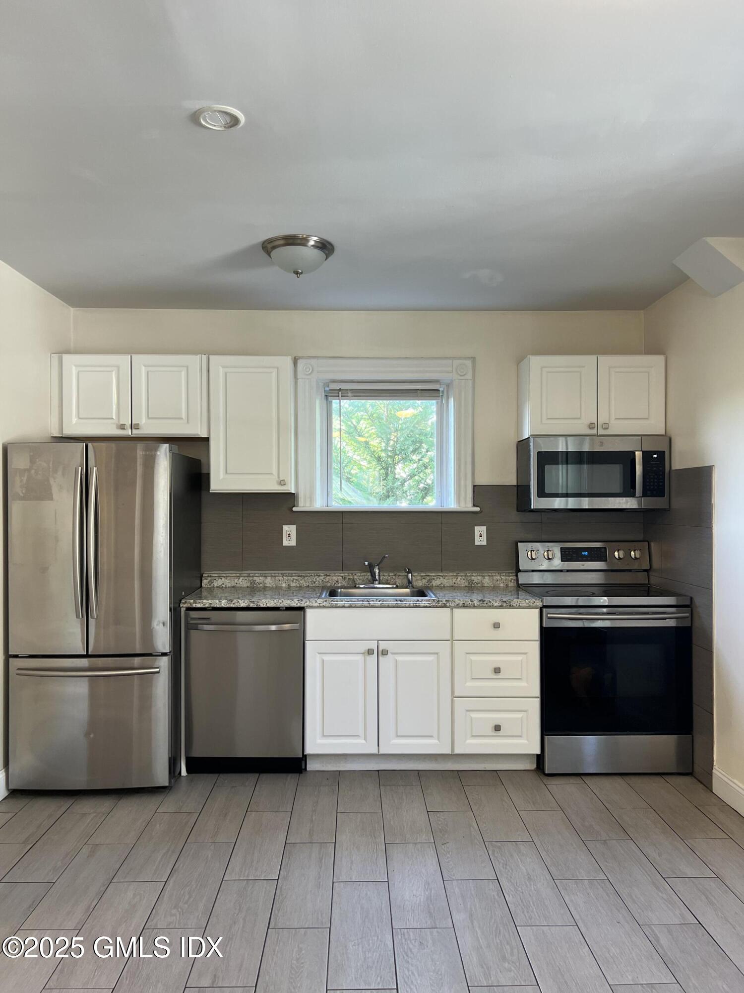 71 Byram Road, Unit 2 Greenwich, CT 06830 - Photo 3 of 10 a kitchen with stainless steel appliances granite countertop a refrigerator and a stove top oven