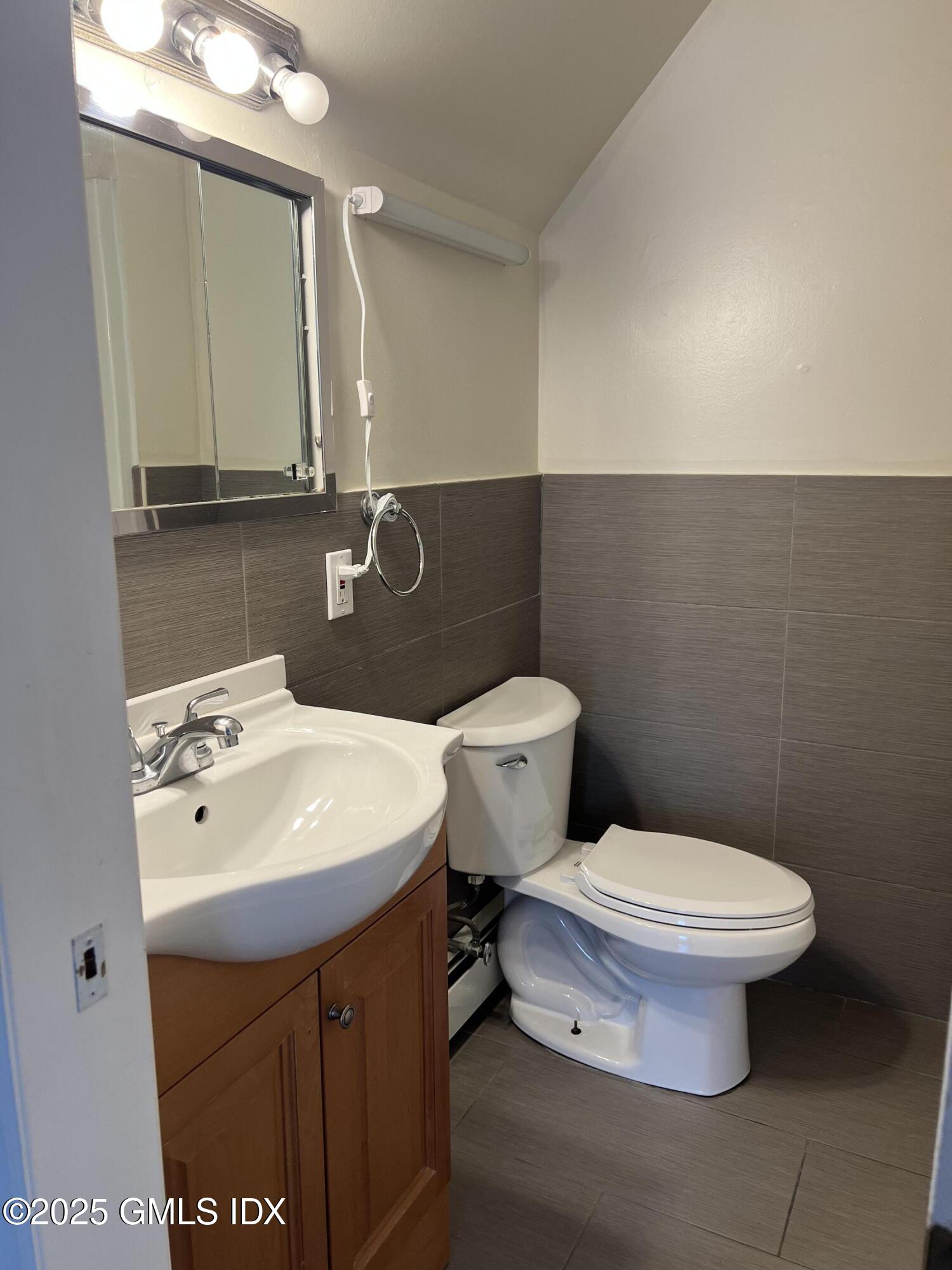 71 Byram Road, Unit 2 Greenwich, CT 06830 - Photo 7 of 10 a bathroom with a sink a toilet and mirror