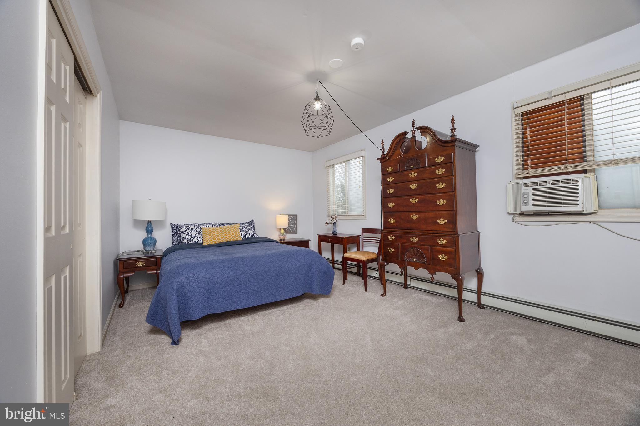 6106 Lower York Road New Hope, PA 18938 - Photo 15 of 20 a bedroom with a bed a chair and a chandelier
