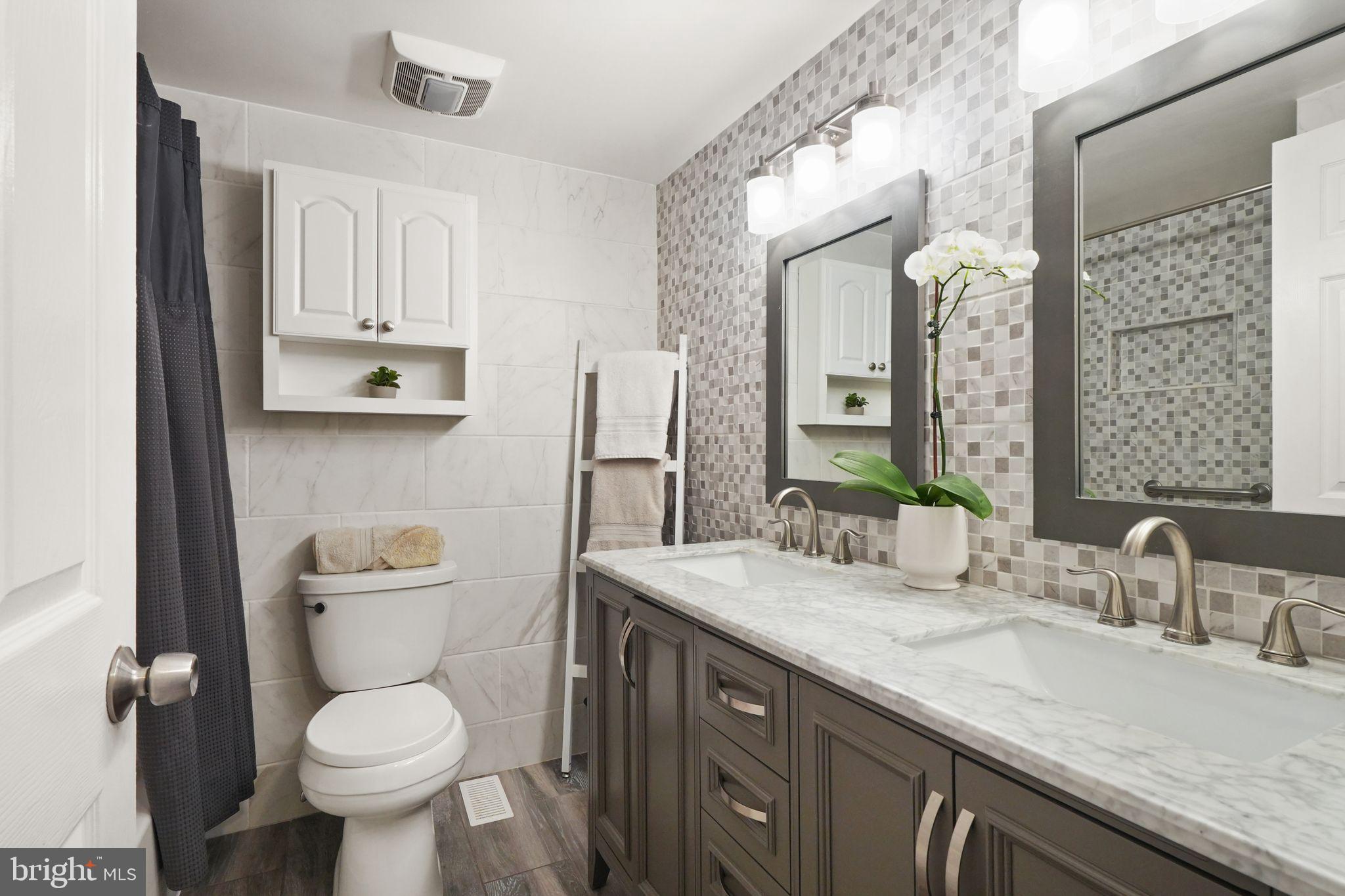 8282 Morning Dew Court Springfield, VA 22153 - Photo 33 of 63 a bathroom with a granite countertop toilet sink and mirror