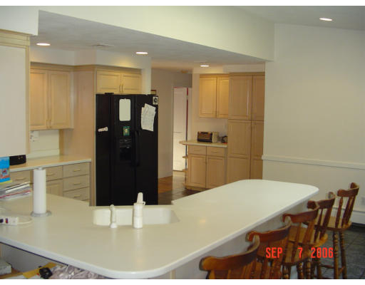 62 Prescott Road Concord, MA 01742 - Photo 3 of 25 a kitchen with a table chairs and a refrigerator