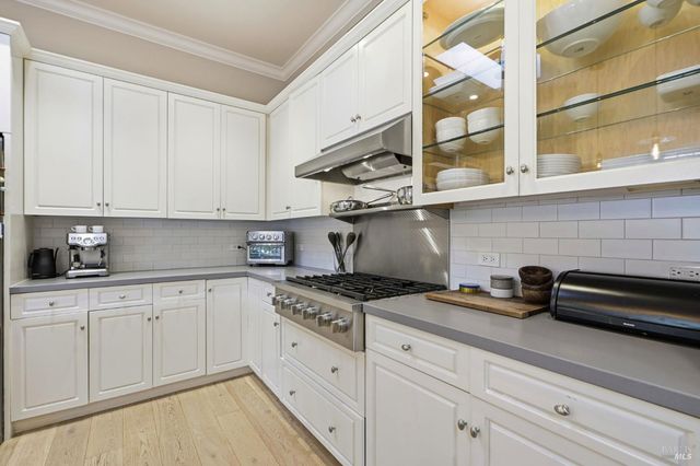 a kitchen with stainless steel appliances granite countertop white cabinets and a stove