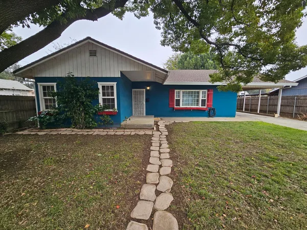 a front view of a house with a yard and potted plants