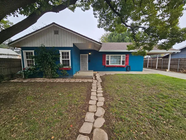 a front view of a house with a yard and potted plants