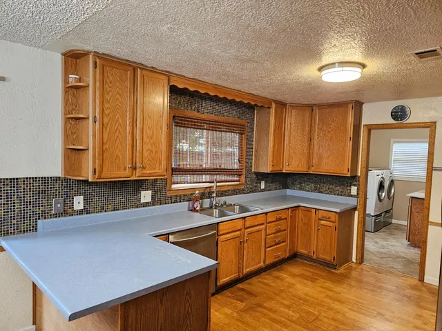 a kitchen with a sink cabinets and wooden floor
