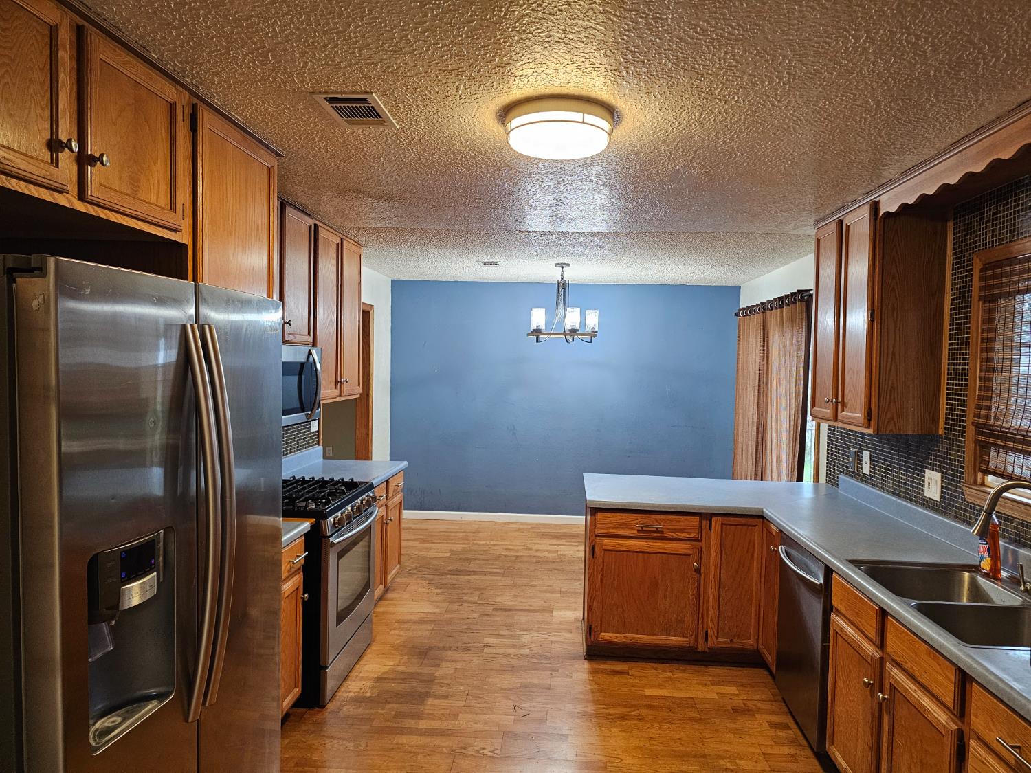 1140 Locust Street Gridley, CA 95948 - Photo 7 of 22 a kitchen with stainless steel appliances granite countertop a refrigerator a stove and a sink
