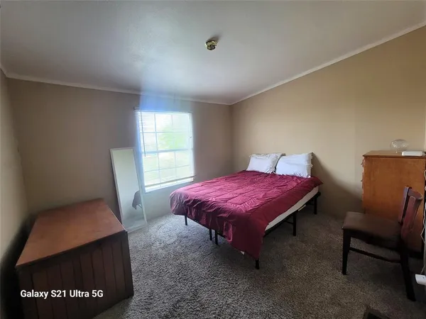 a spacious bedroom with a bed and a window