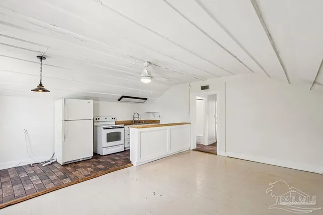 a large kitchen with a stove and white cabinets