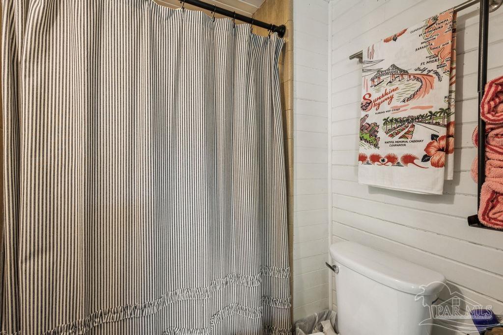 600 East Jackson Street Pensacola, FL 32501 - Photo 37 of 45 a white toilet sitting next to a shower curtain