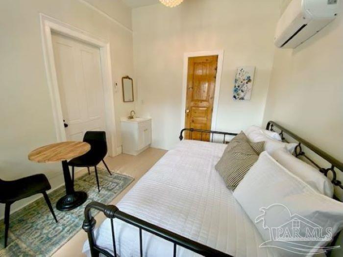 600 East Jackson Street Pensacola, FL 32501 - Photo 38 of 45 a bedroom with a bed and a chandelier
