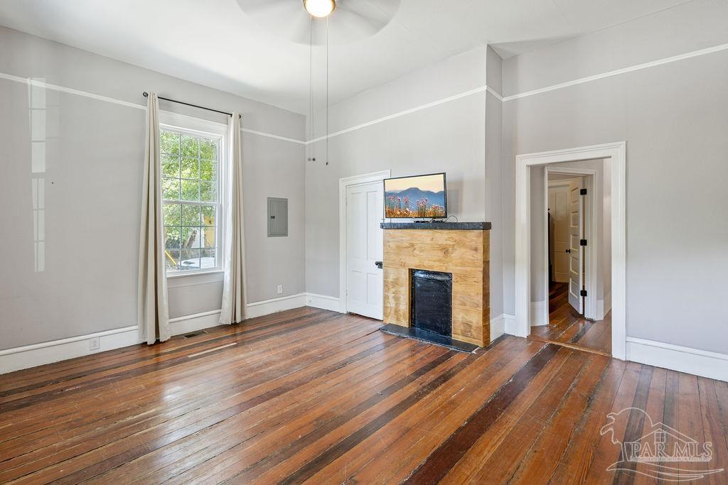 600 East Jackson Street Pensacola, FL 32501 - Photo 4 of 45 an empty room with wooden floor fireplace and windows