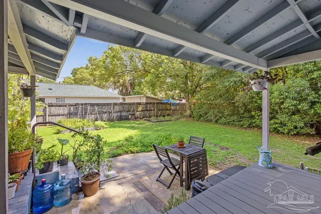 a view of a patio with table and chairs potted plants with wooden floor and fence
