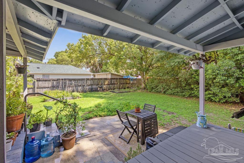 600 East Jackson Street Pensacola, FL 32501 - Photo 41 of 45 a view of a patio with table and chairs potted plants with wooden floor and fence