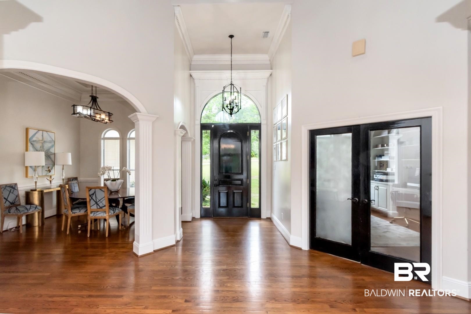 2640 Meadowlake Road Semmes, AL 36575 - Photo 9 of 55 Foyer entrance featuring suspended lighting, crown molding, dark wood-style floors, arched walkways, and french doors